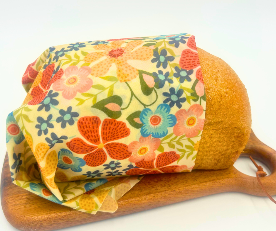 Wrapped bread on a wooden cutting board with a colorful floral pattern on the bread wrap.