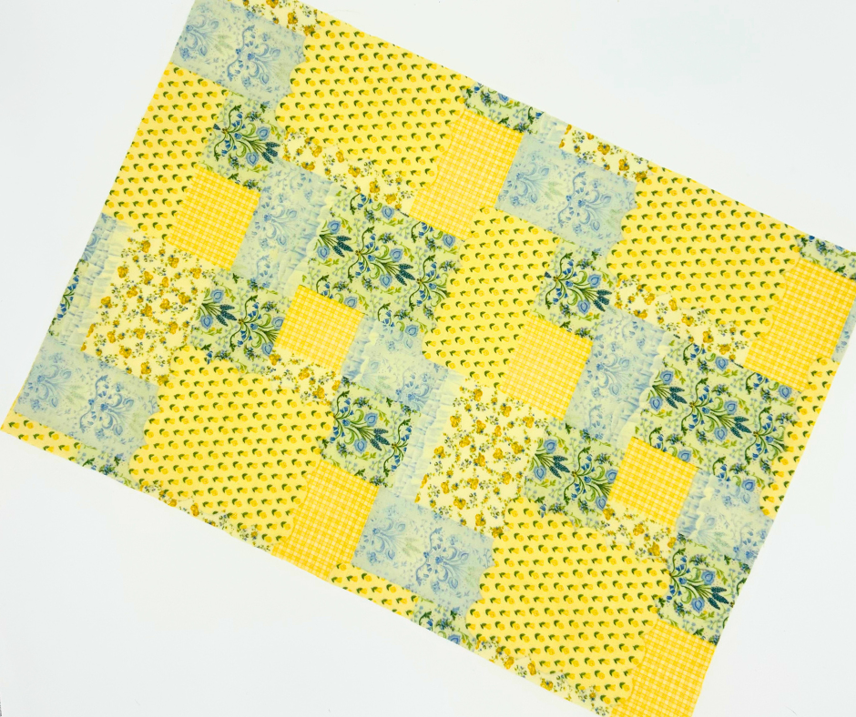 Patchwork quilt with yellow and green pattern on a white background