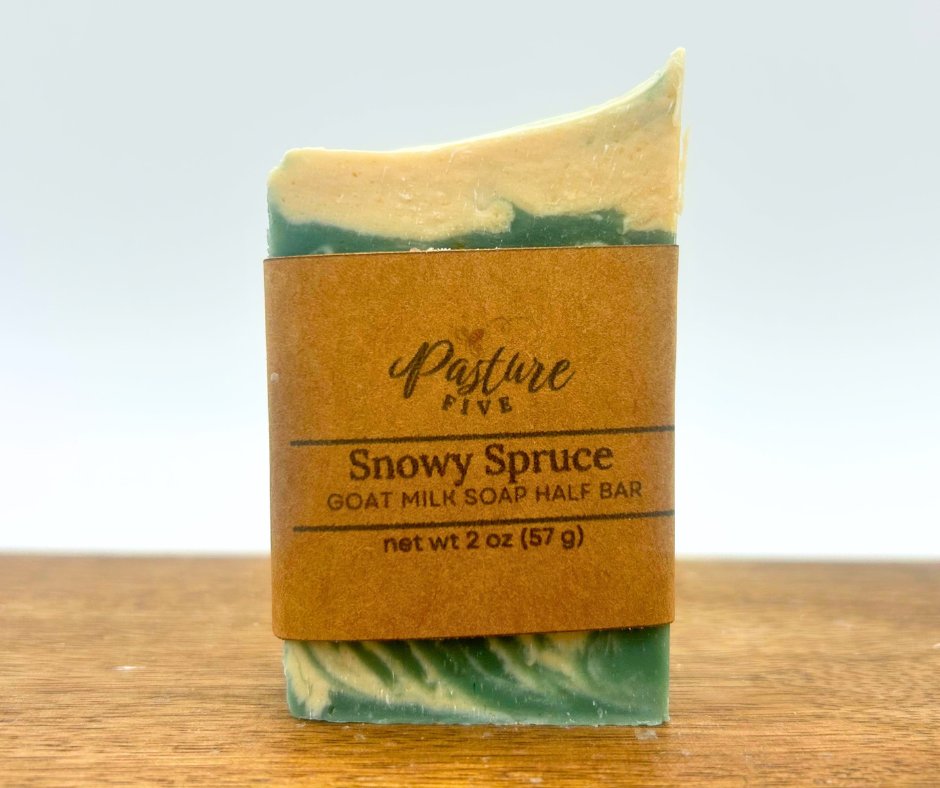 One 2oz bar of Snowy Spruce Goat Milk Soap on a wood board.