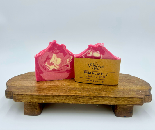 Pink and white soap bar with a wooden stand on a white background