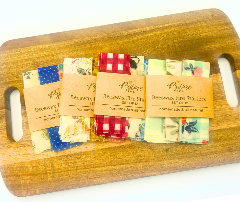 Set of beeswax fire starters on a wooden board with visible Pasture Five labels.