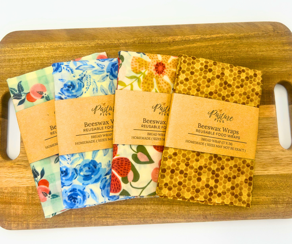 Sets of beeswax wraps with floral designs on a wooden board.