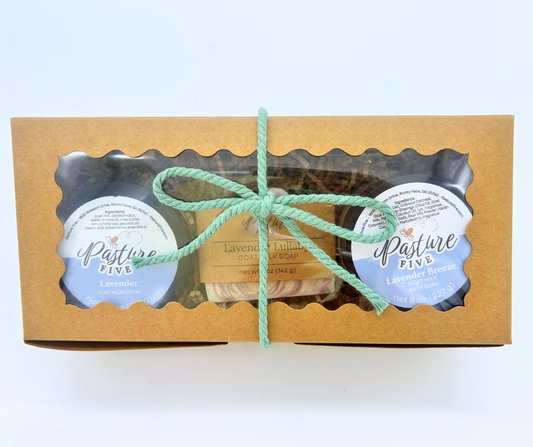 The Farmhouse Christmas Gift Box with a lotion, soap bar, and bath soaks in a gift box with green ribbon. 
