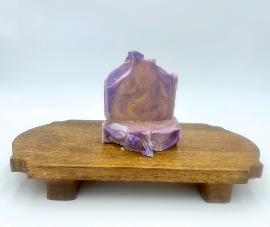 Decorative goat milk soap on a wooden stand with a white background