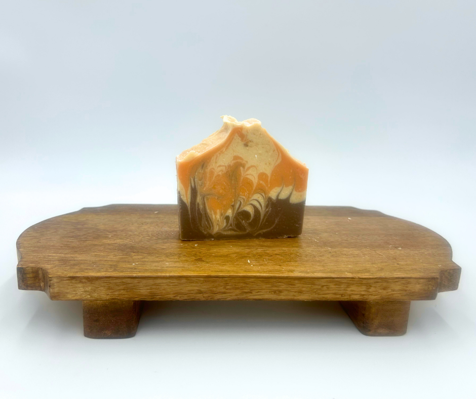 Decorative goat milk soap on a wooden stand with a white background