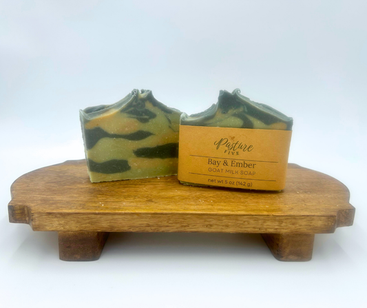 Two soaps on a wooden stand with a white background