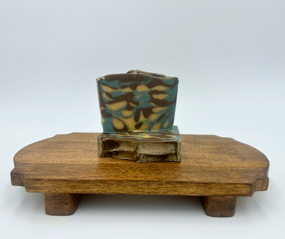 two blue harvest soap bars on a wooden stand against a white background