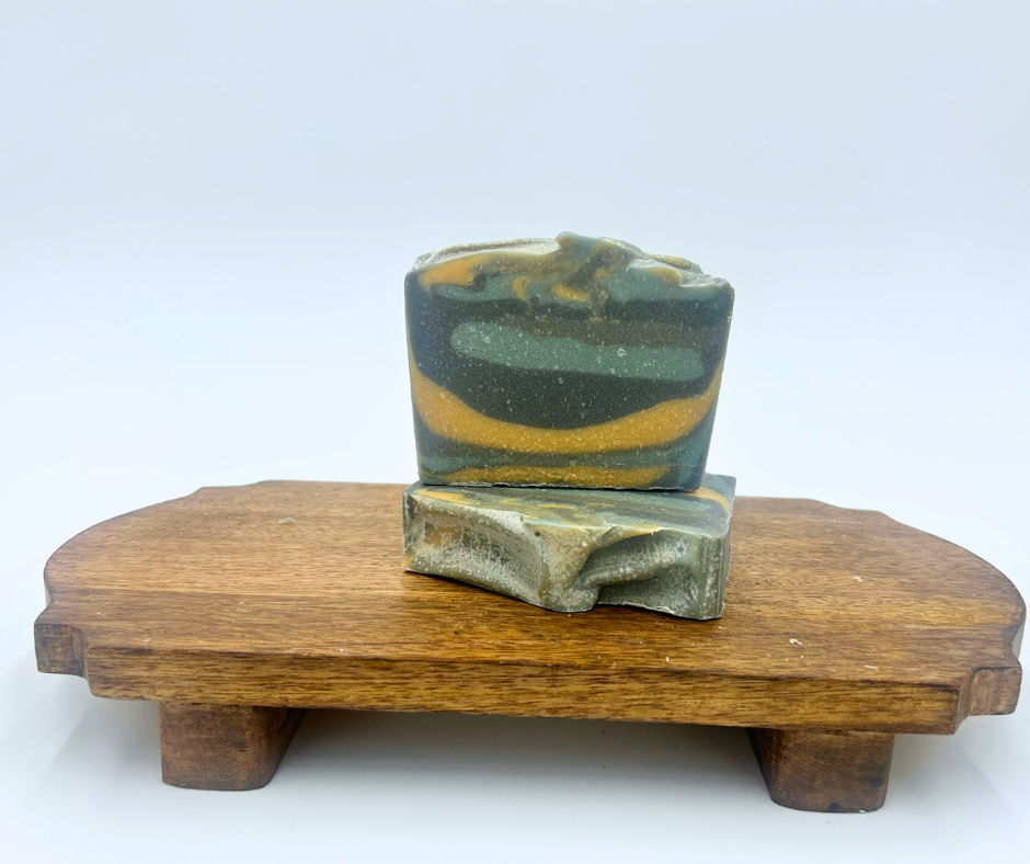 Two layered soap bars on a wooden stand with a white background