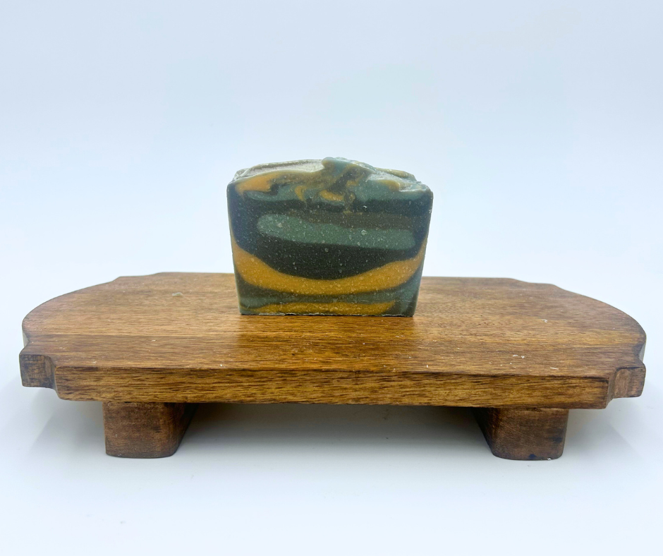 a layered soap on a wooden stand with a white background