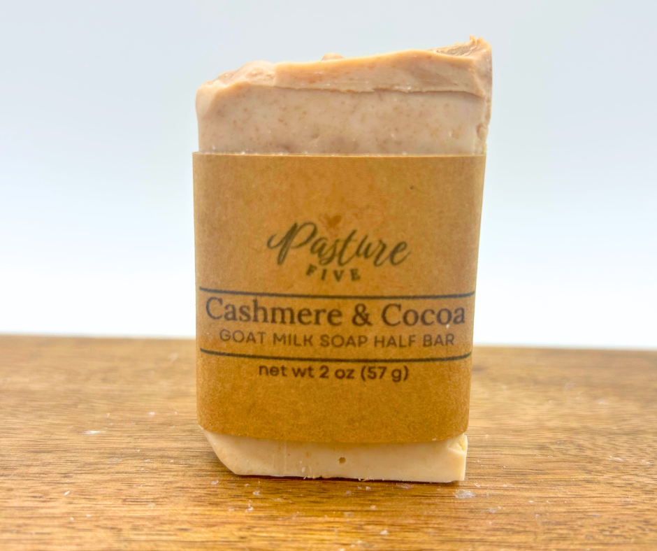 One 2oz  bars of Cashmere & Cocoa with a wrap on a wood board. 