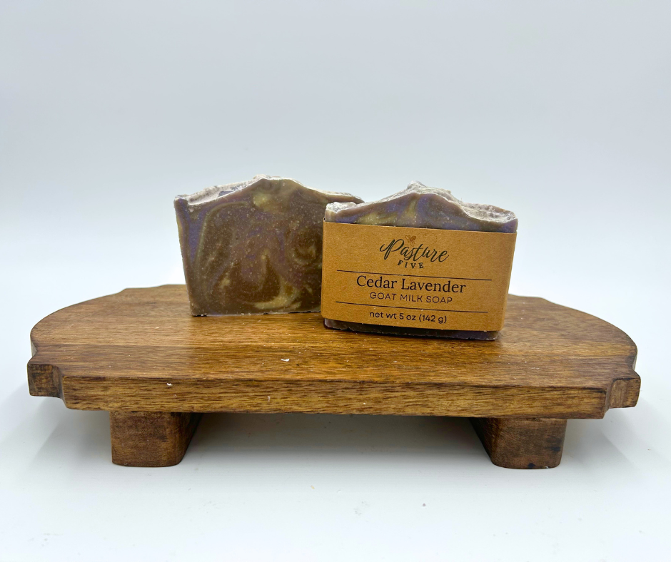 Two Soaps on a brown platform. Cedar Lavender, purple, brown, and Cream. 
