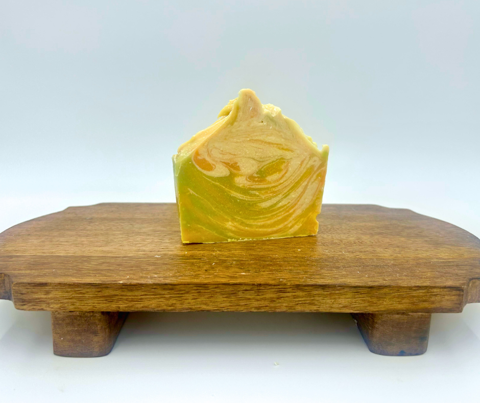 Yellow, Orange and Green, Cream soap bar on a wooden stand with a white background