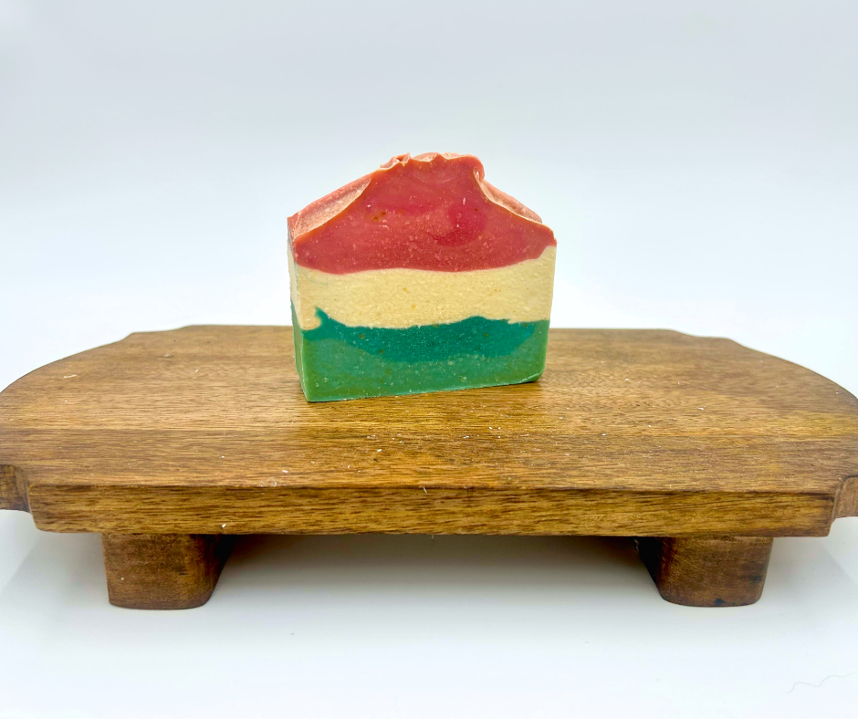 Colorful layered soap on a wooden stand with a white background