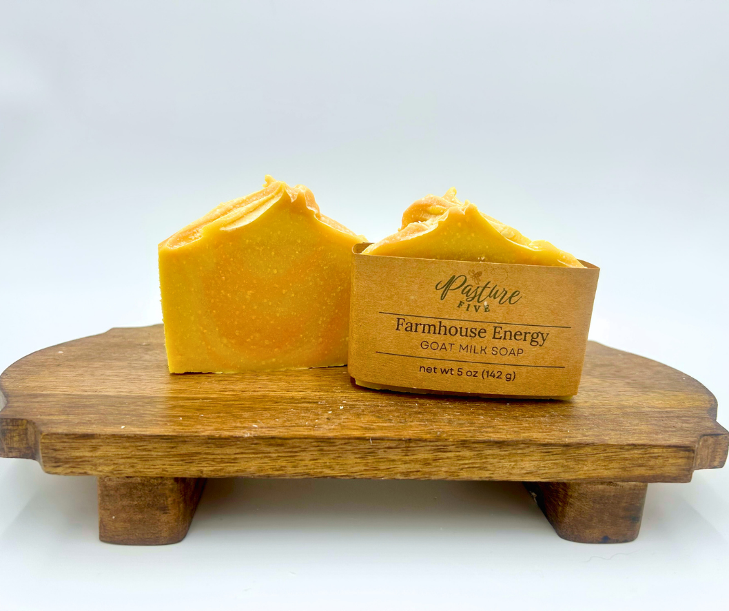 Two bars of  soap on a wooden stand with 'Pasture Five' branding.