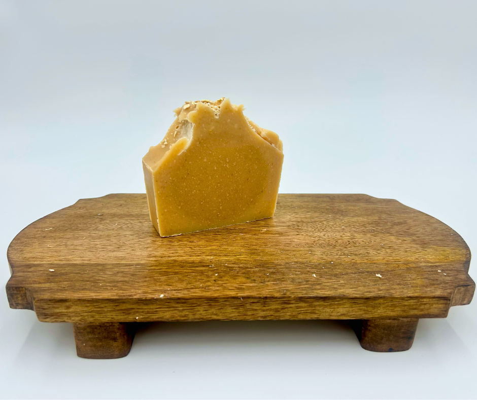Bar of soap on a wooden stand against a white background
