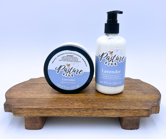Lavender pump and jar lotion on a brown table with white background