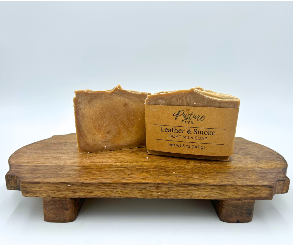 Two bars of soap on a wooden stand with a white background