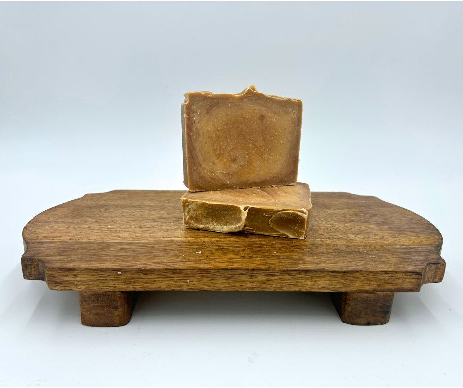 two bars of brown swirl soap stacked on top of each other on brown platform.