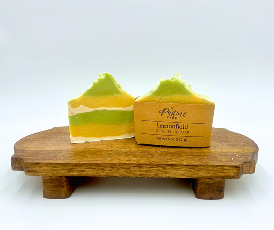 layered green, white, and yellow soap bars on a wooden stand with a label reading 'Lemonfield'.