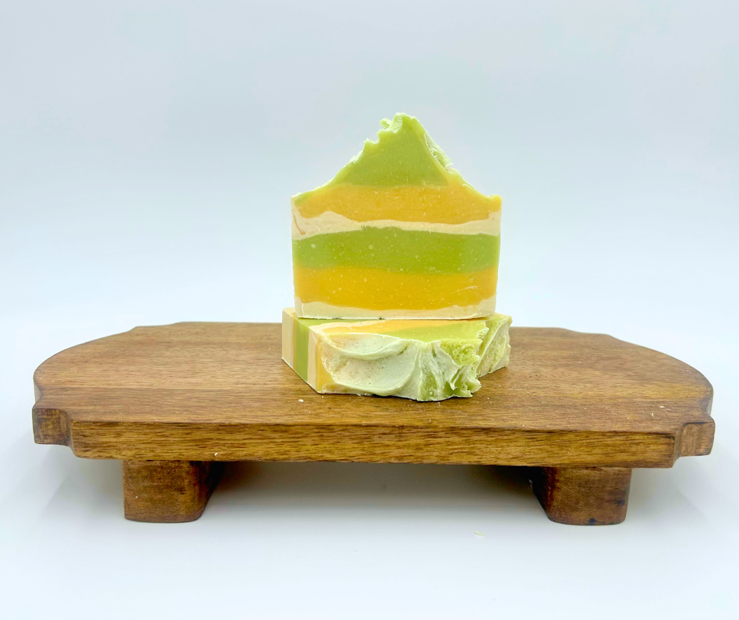 Layered soap bar on a wooden stand with a white background