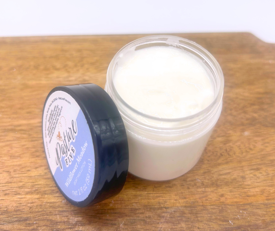 Mini Jar of lotion open on a wood board. 