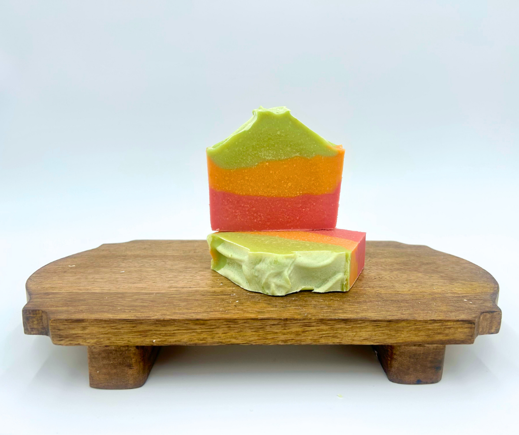 Colorful layered soap on a wooden stand with a white background