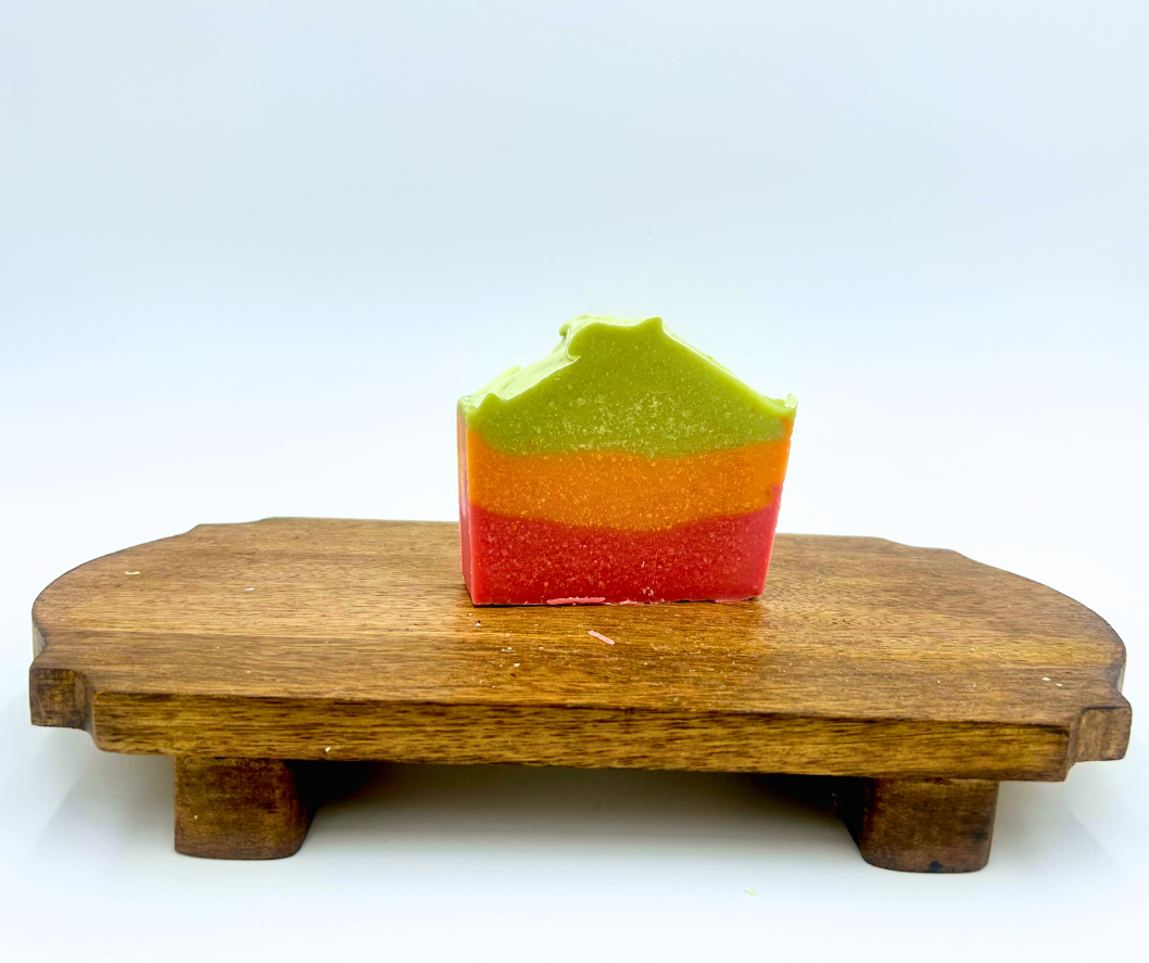 Colorful layered soap on a wooden stand with a white background