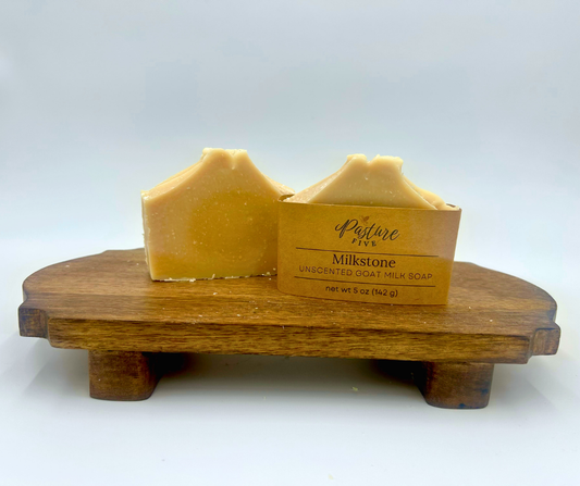 Two bars of soap in Pasture Five packaging on a wooden stand with a white background