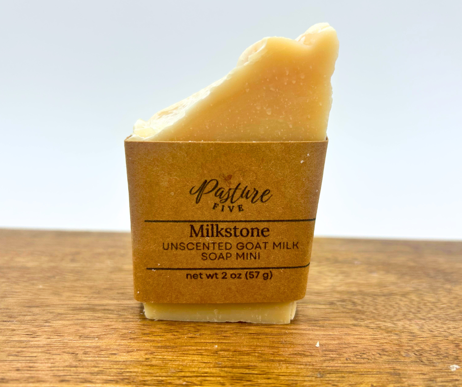 Half Bar of soap in a brown paper packaging with 'Pasture Five' branding on a wooden surface.