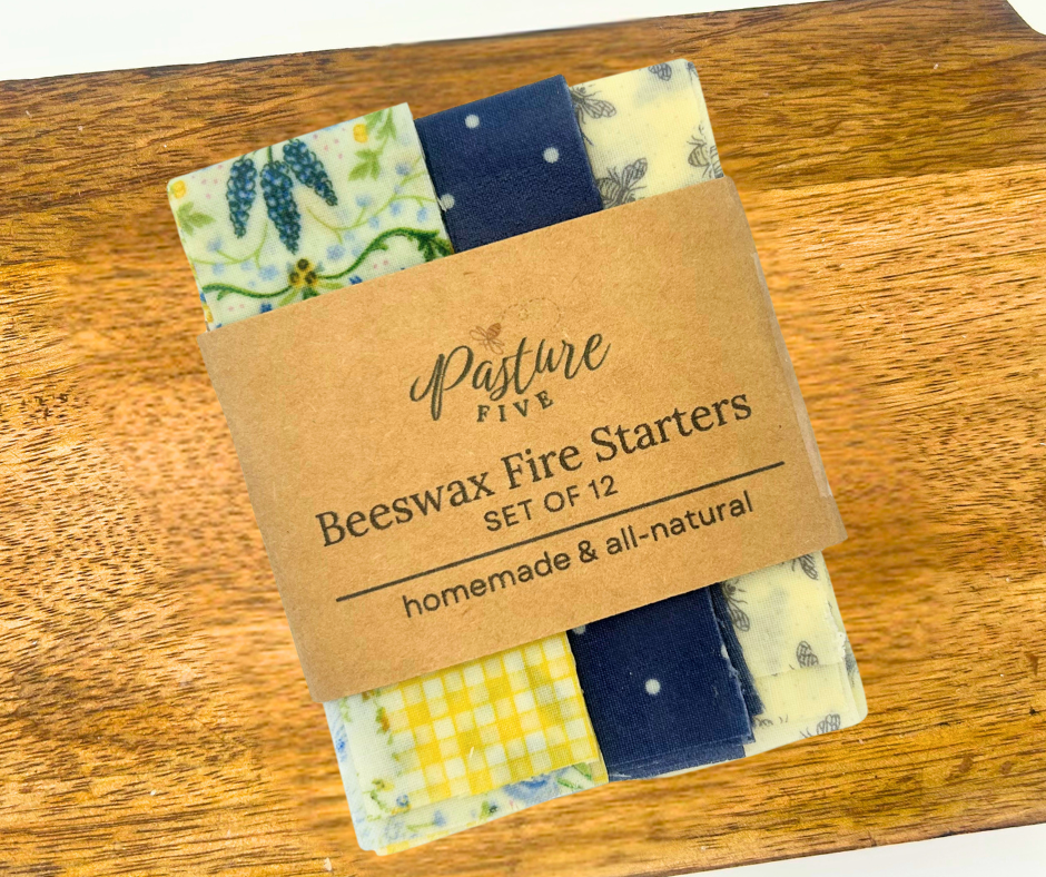 Set of beewax fire starters with a 'Pasture Five' label on a wooden surface