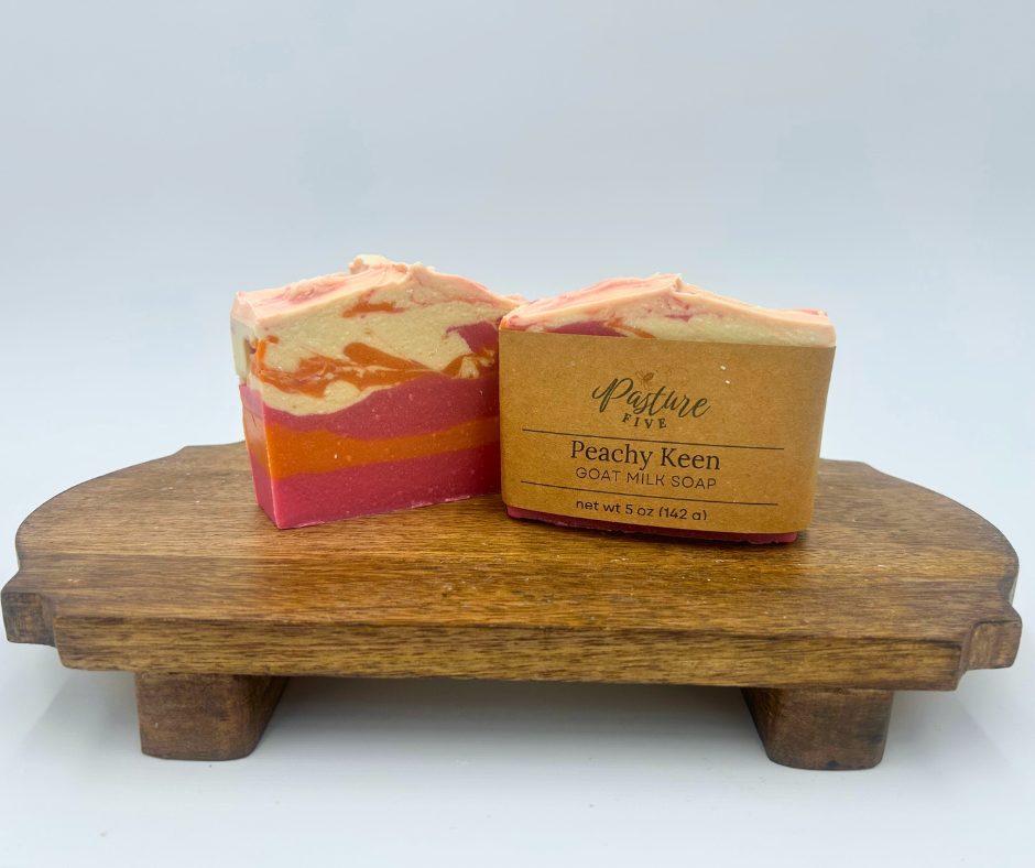 Two bars of soap with a wooden stand on a white background