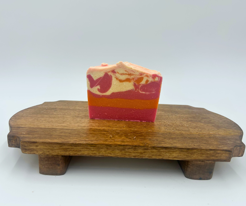 Bar of soap with a marbled pattern on a wooden stand against a white background
