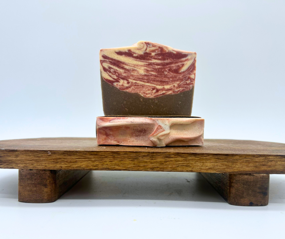 Two bars of Peppermint Cocoa Goat Milk Soap on a wooden board. 