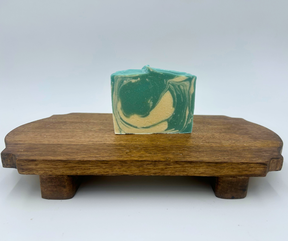 one blue and white swirl goat milk soap on a brown stand 