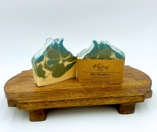 Two bars of soap on a wooden stand with a white background