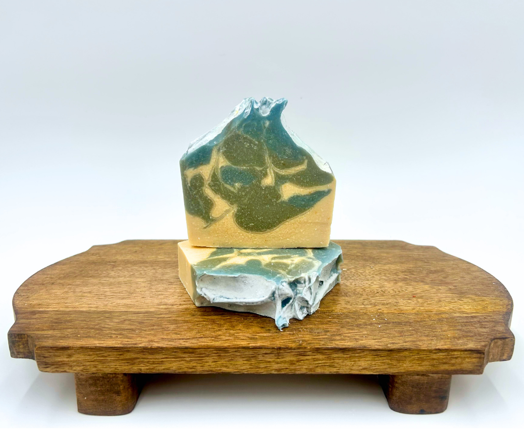 Blue and white marbled soap on a wooden stand with a white background