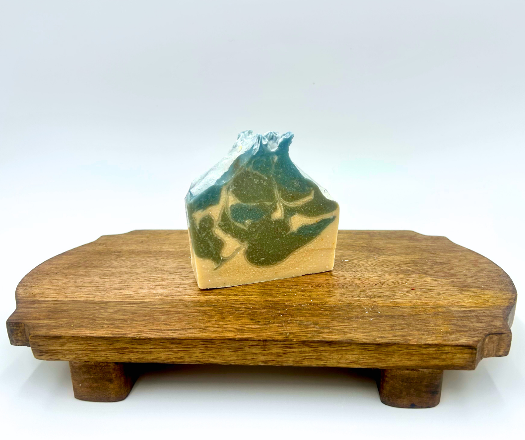 Bar of blue and white soap on a wooden stand with a white background