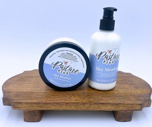 Two bottles of 'Pasture Five Sky Meadow' on a wooden stand with a light blue background