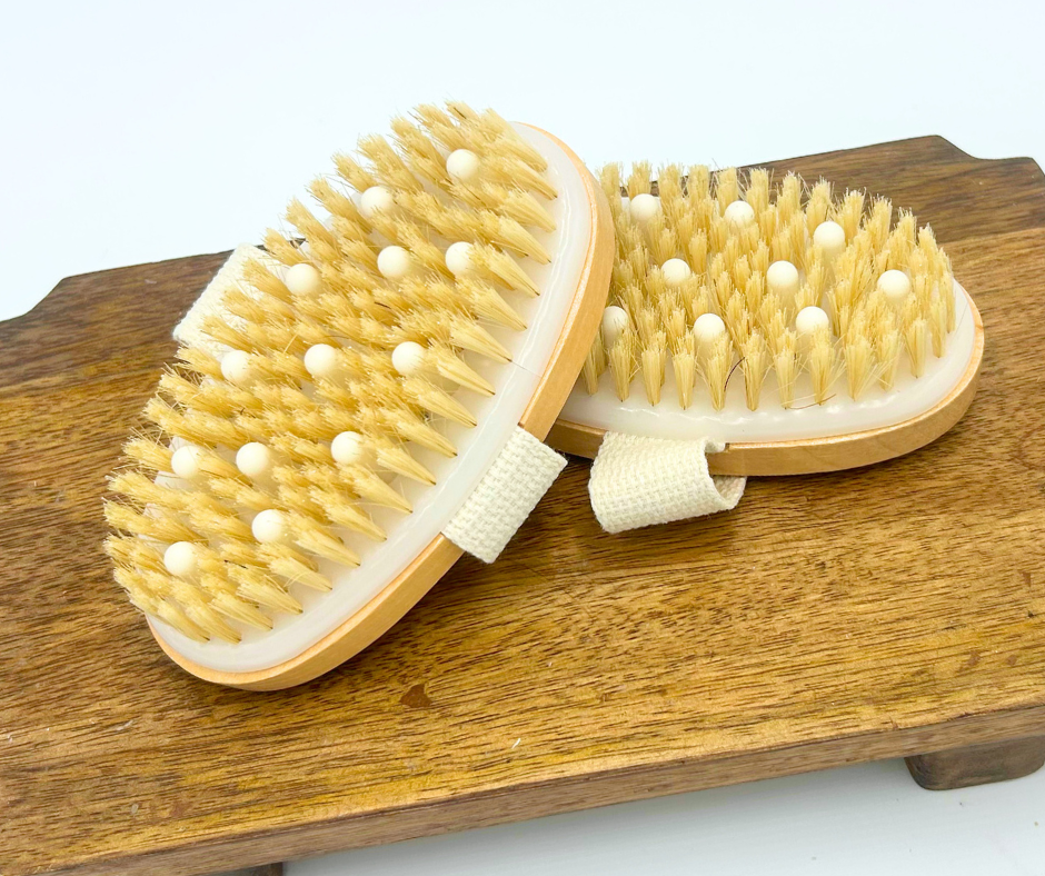 Two massage brushes with natural bristles on a wooden surface