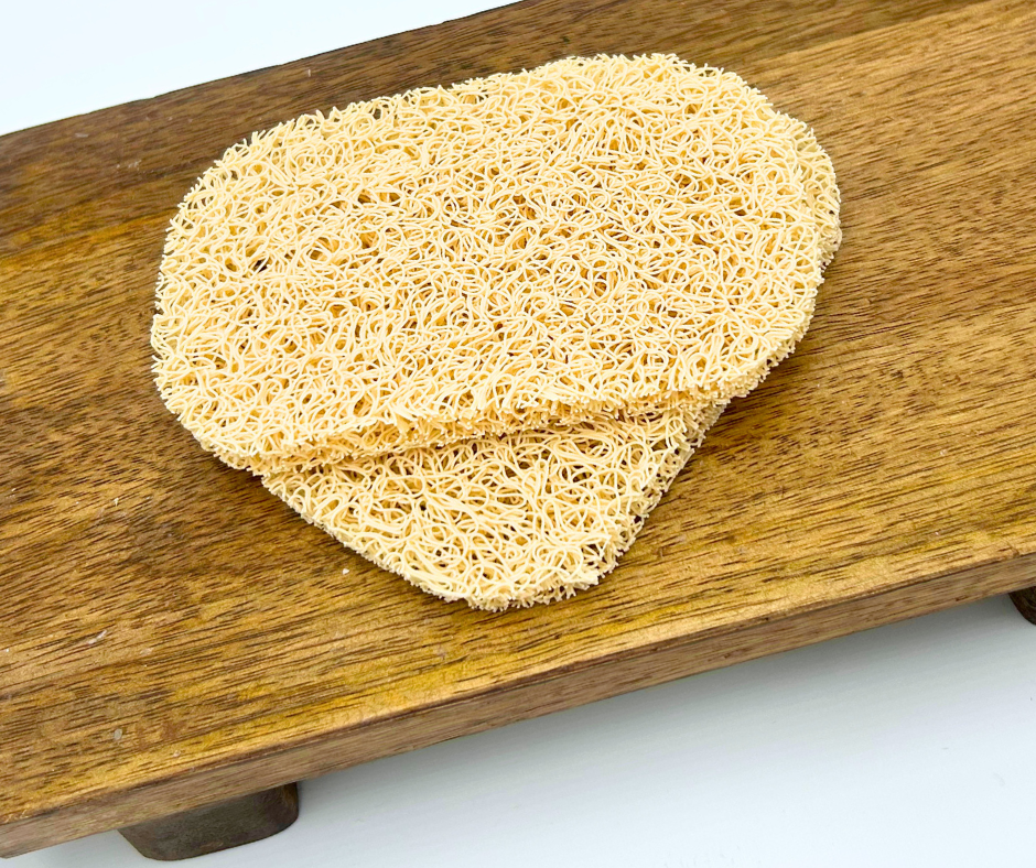 Two soap saver pads on a wooden board with a white background