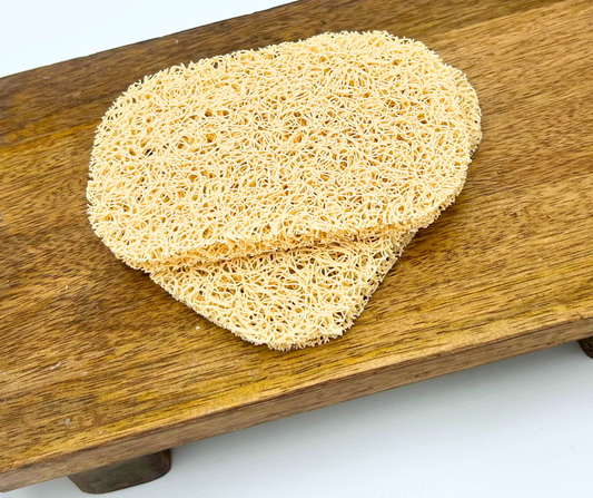 Two soap saver pads on a wooden board with a white background