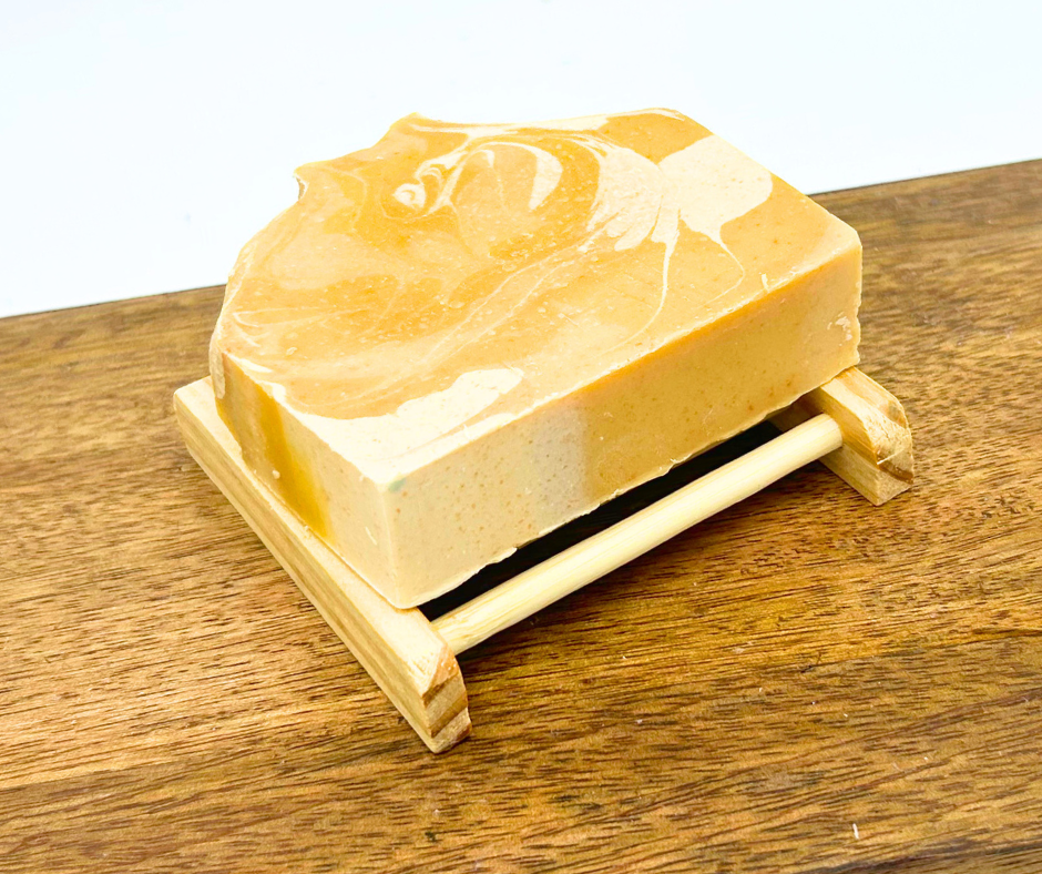 Bar of soap on a wooden soap dish with a white background