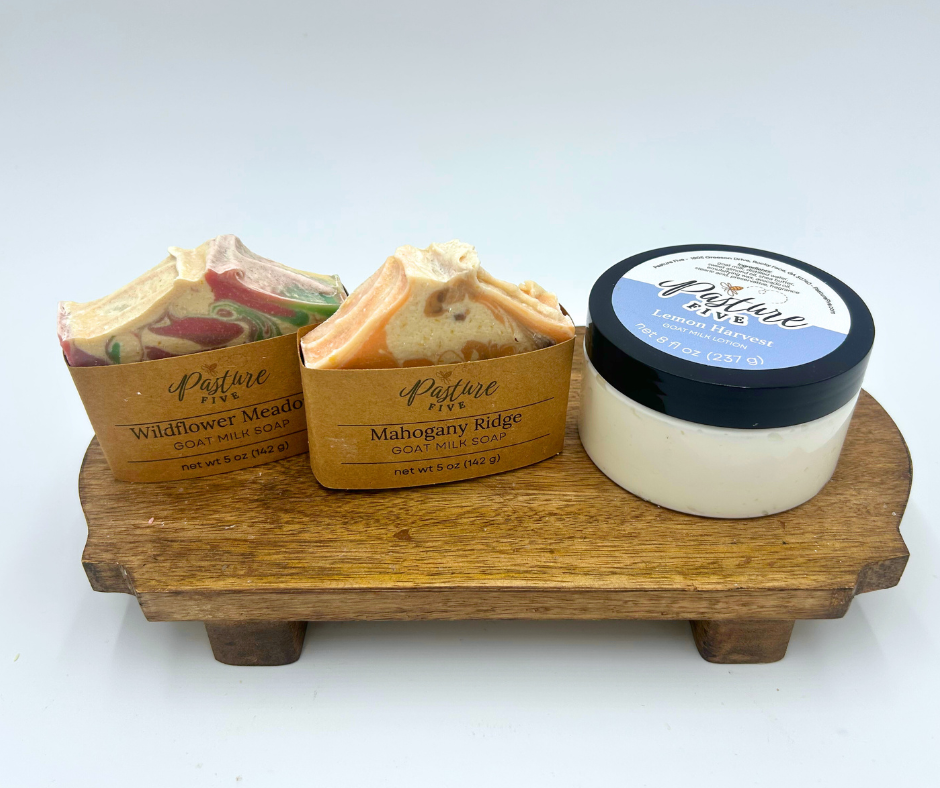 Three soap products on a wooden stand with 'Nature's Pride' branding.