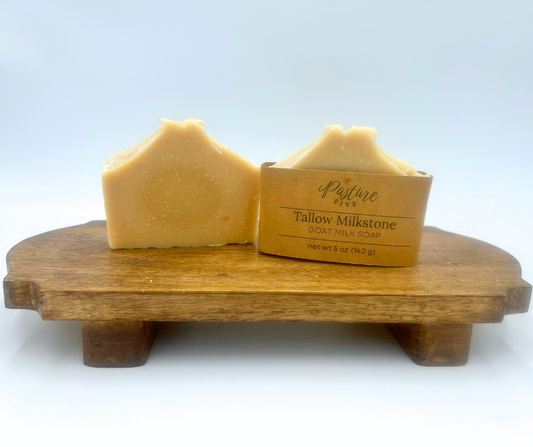 Two bars of soap on a wooden stand with a white background