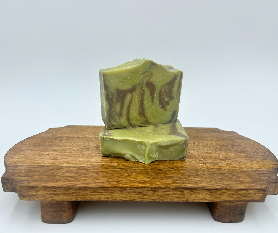 two green and brown swirl goat milk soap bars on brown stand