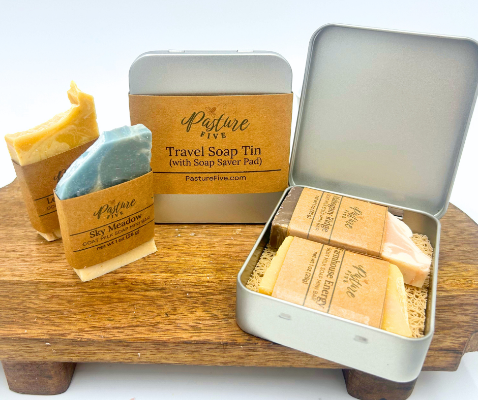 Travel soap tin with soap bars and packaging on a wooden stand