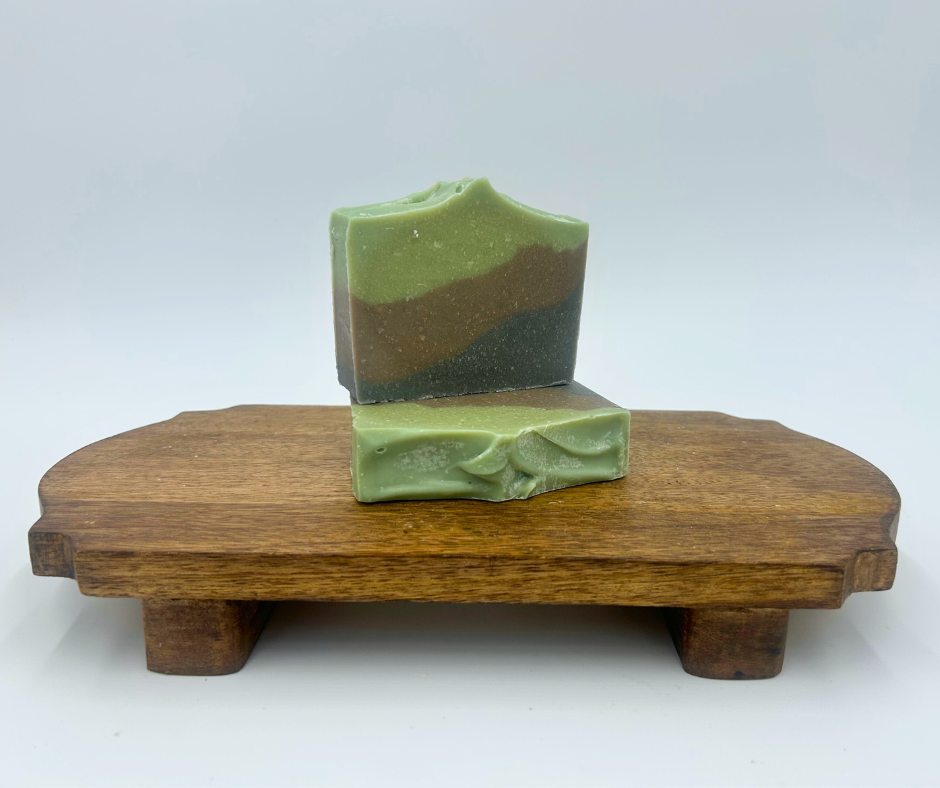 two layered goat milk soaps on a brown stand 