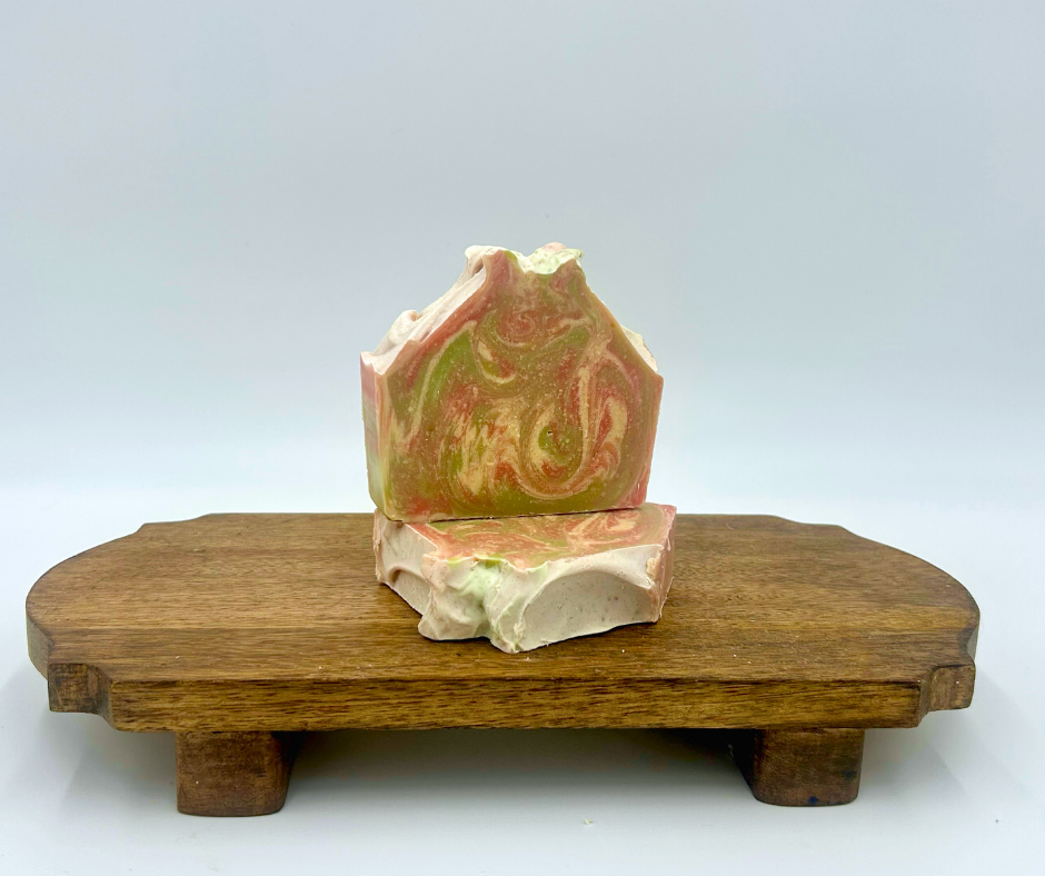 Decorative soap bar with marbled design on a wooden stand against a white background
