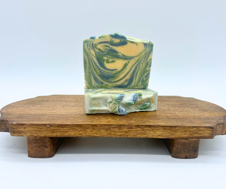 Two bars of Winterberry Goat Milk Soaps on a wood board. 