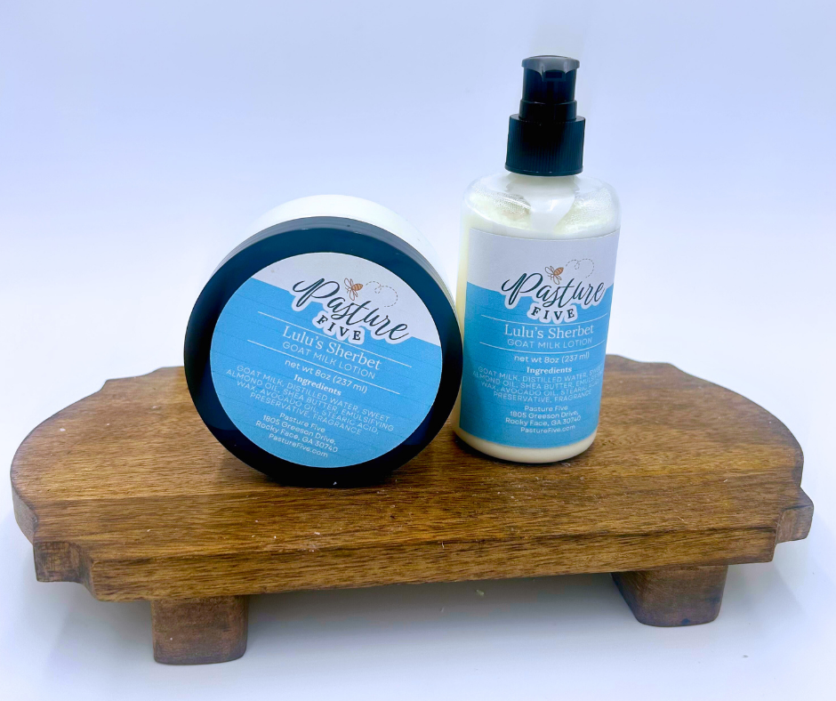 Two bottles of 'Pasture Five' Lulu's Sherbet lotion on a wooden stand with a white background